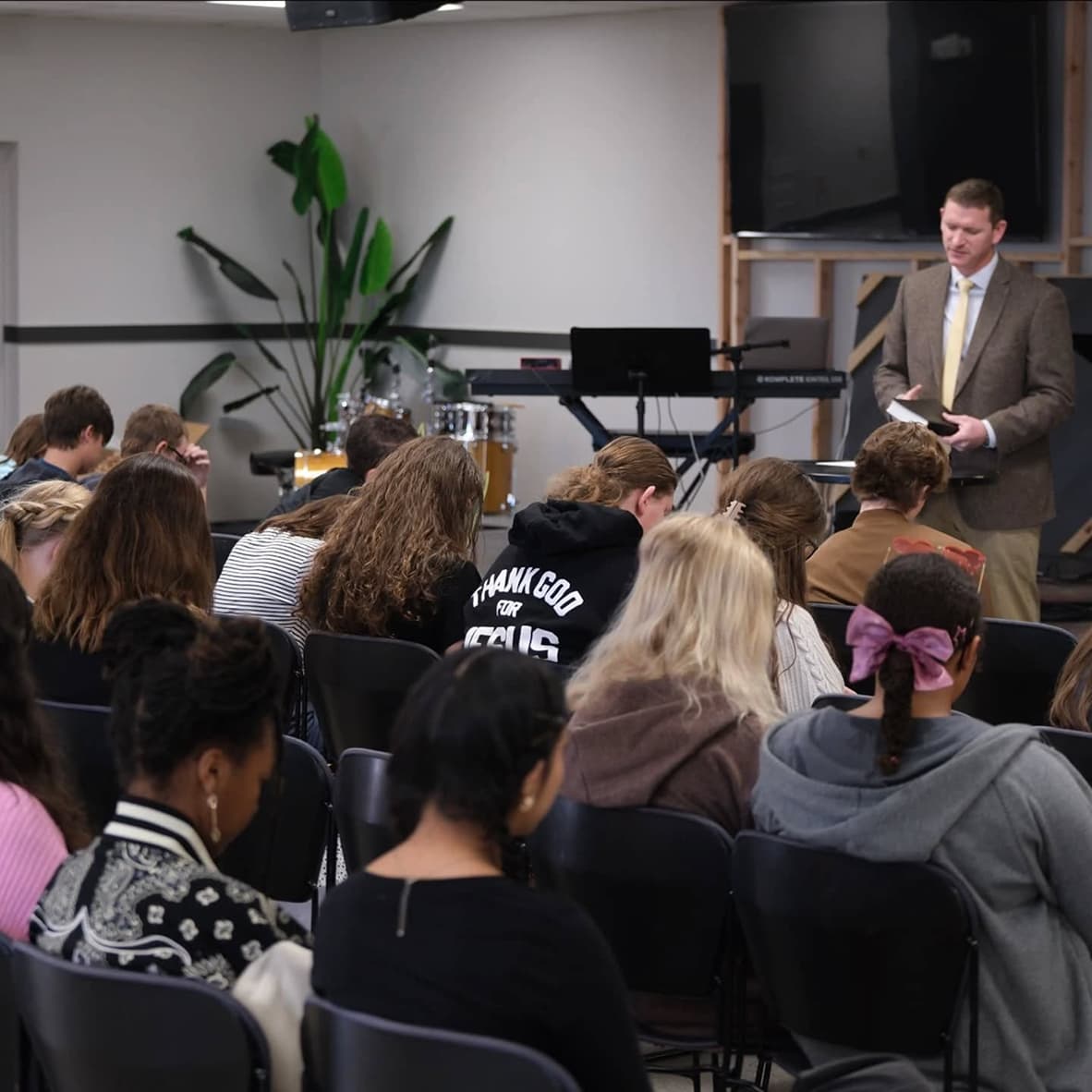 Pastor praying to the students